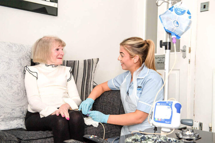 A live-in care assistant delivers nutrition to a live in care client